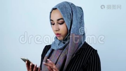 年轻美丽的阿拉伯女人拨打电话，从智能手机上打电话给一个人视频