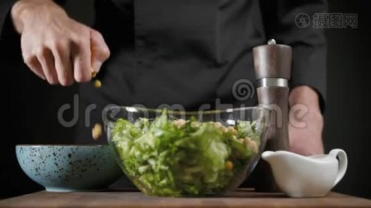 厨师在黑底的绿色沙拉中加入豌豆视频
