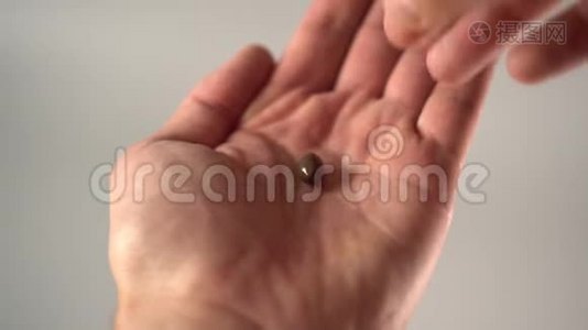 一只手从手掌上取出一个医用棕色胶囊视频