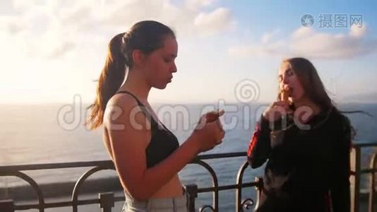 两个年轻女子站在海边码头，训练后吃冰淇淋视频