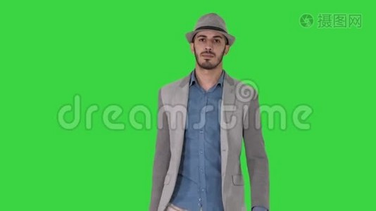 随意的阿拉伯男人戴着帽子，带着公文包走在绿色屏幕上，ChromaKey。视频