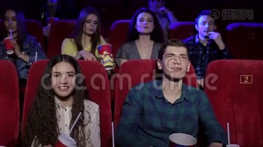 一对快乐的年轻夫妇在电影院里扔爆米花。视频