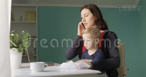 成功的母亲正在内政部工作，带着婴儿的儿子在桌子上乱放文件和文件视频