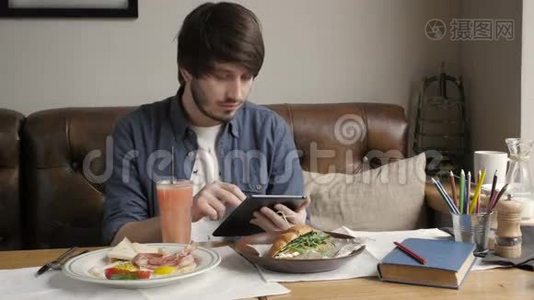 使用数码平板电脑吃健康早餐的嬉皮士视频