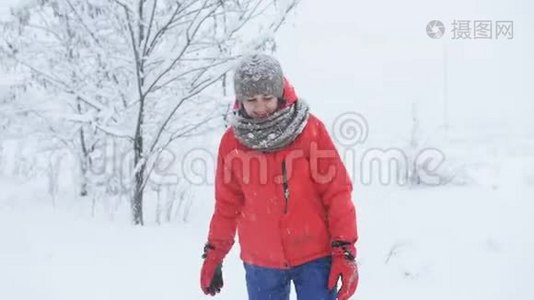 冬天的树林里，一个穿着红色夹克的女人喜欢下雪，扔雪。视频