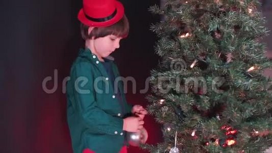一个孩子把玩具放在圣诞树上。视频