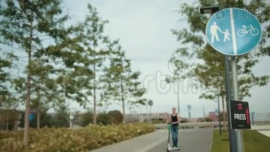 穿着黑色衣服和牛仔裤的男人，骑着电动滑板车在城市里转悠视频