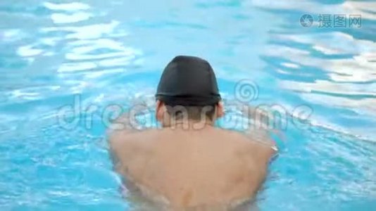 男子游泳运动员在游泳池训练时做蝶泳动作，慢动作。视频