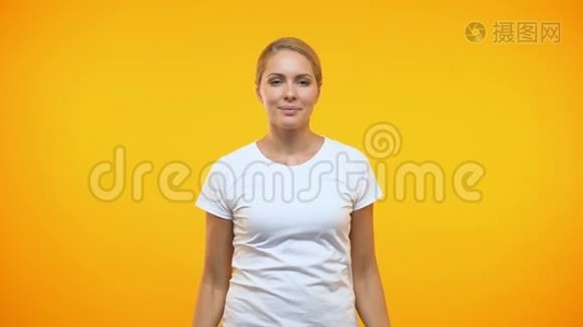 微笑的漂亮女士展示橙色背景的购物袋，假日销售视频
