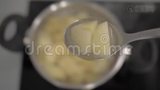 土豆片放在一个大汤匙里，放在土豆锅的背景上。4k.4k视频视频