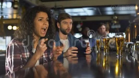 双种族女孩和男迷在酒吧里看体育比赛，对比分失望视频
