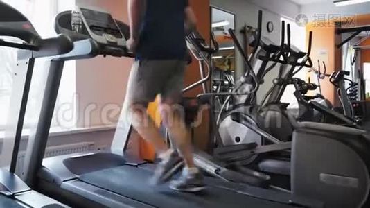 无法辨认的人在健身工作室的跑步机上跑步。 倾斜长射视频