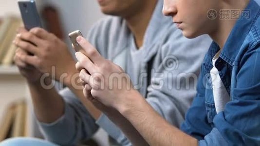两名青少年在智能手机上玩快速电子游戏，手机游戏应用程序视频