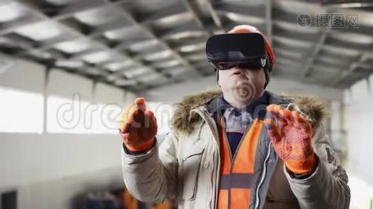 戴着安全帽和工作服的人正站在机库中间，用虚拟现实眼镜改变设置视频