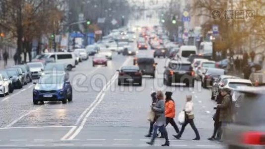 人们在繁忙的城市街道上过马路。 交通高峰期。 一群无名行人穿过繁忙的城市视频