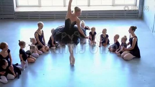 芭蕾舞学校的女舞蹈演员学会跳舞。 穿着黑色舞服训练的小芭蕾舞女。 孩子们`芭蕾视频