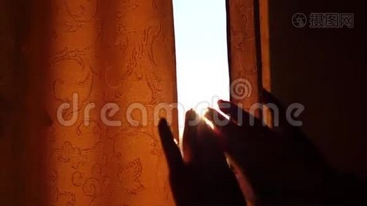 那个女孩在清晨拉开窗帘。 太阳`光线穿过窗户和手指视频