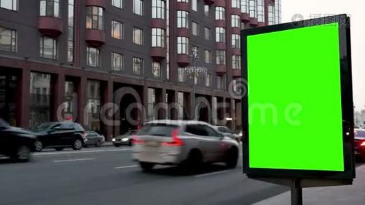 城市街道。天。展示一个大的绿色屏幕。汽车来了。视频