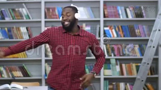 戴着耳机的快乐黑人在图书馆跳舞视频