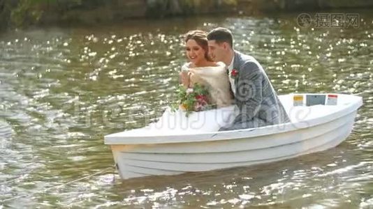 带着花束的女孩和她的丈夫正在池塘里游泳。 新婚夫妇很幸福。视频