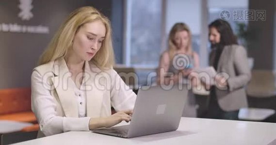 年轻的白人女性在笔记本电脑键盘上打字的肖像。 自信成功的CEO在工作场所的肖像视频