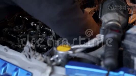 机修工手上戴着手套`他修理汽车里的发动机。视频
