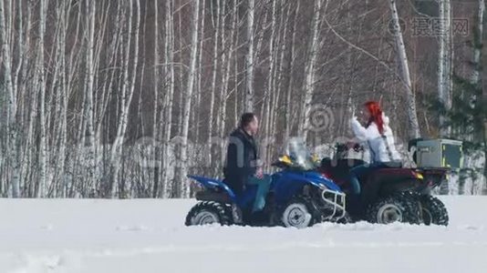 冬天的森林。 一男一女坐在雪地摩托上互相击掌视频