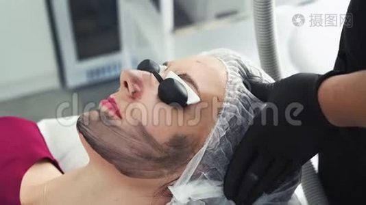 美容诊所碳面剥离手术中戴防护眼镜的年轻女性视频