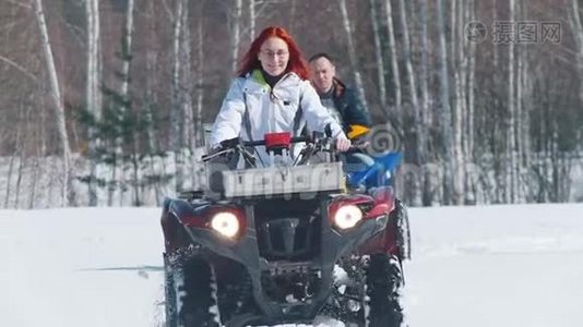 穿着冬装的男女在森林里骑着雪地摩托视频