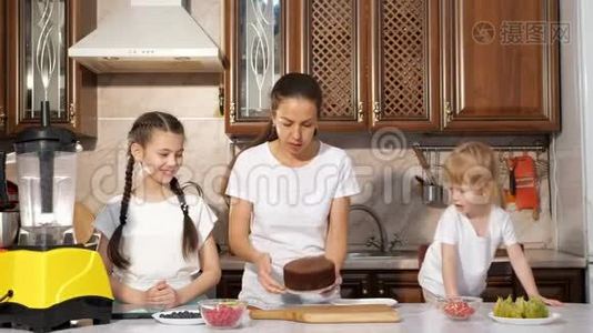 妈妈正和她的两个小女儿在厨房里烤蛋糕。视频