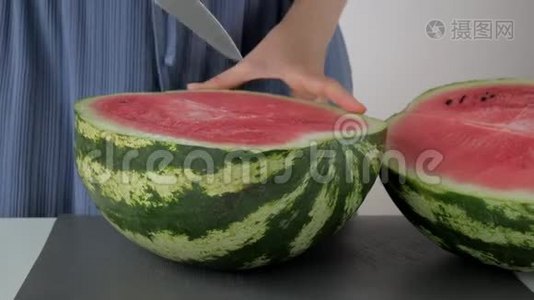 女用手用刀切下一半大的绿色西瓜视频