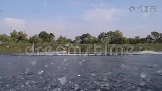 极限运动，冲浪者骑在摩托艇后面的河上，背景是大自然和蓝天视频