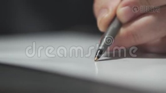 男人`用圆珠笔在白纸上画画。视频
