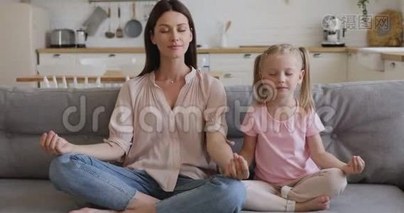 健康快乐的妈妈教小女儿坐在沙发上视频