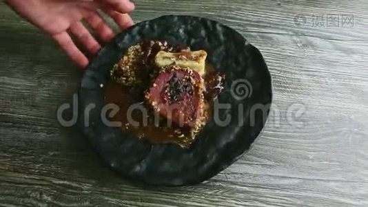 人手旋转黑色盘子，时髦的装饰肉排视频