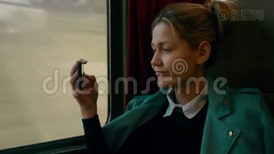 年轻的高加索商务女性正乘坐豪华的城际列车。 使用手机拍照。 慢慢视频