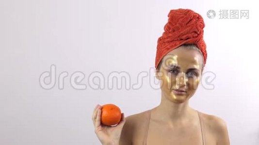 女孩的脸上戴着金色的面具，而不是橙色的水果视频