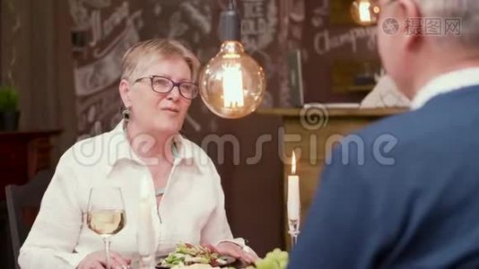 一个年纪相当大的女人为了一杯酒和她的伴侣聊天视频