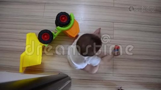 高角镜头，可爱的七个月大的男孩在地板上玩教育玩具视频