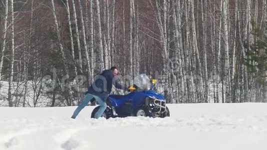 冬天的森林。 一个人试图把雪车从雪堆里弄出来视频