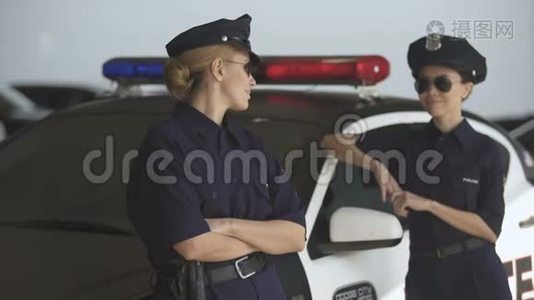 两名身穿警服的妇女站在巡逻车旁微笑着，遵守法律和秩序视频