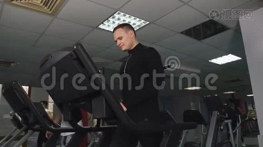 男运动员，在健身房锻炼。 一个男人在运动俱乐部的跑步机上训练。视频