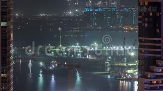 鸟瞰迪拜码头摩天大楼与建筑工地和棕榈朱美拉岛背景夜间时间推移。视频