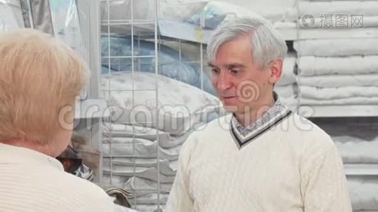 一位老人和妻子一起在家具店挑选床上用品视频