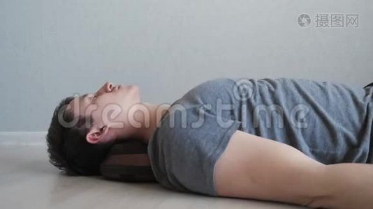 累的家伙躺在地板上用电按摩枕头视频