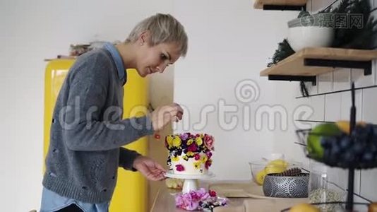 专业糖果女人装饰蛋糕与花白色现代厨房工作室。 副厨女厨师视频