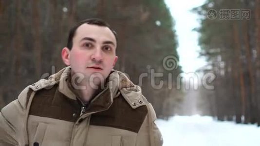穿夹克的人的肖像在冬天的森林里出现了拇指视频