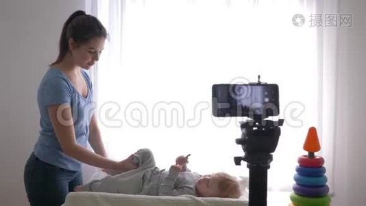宝贝体操，年轻的博主妈妈给小儿子做热身，并用相机手机录制现场辅导视频视频