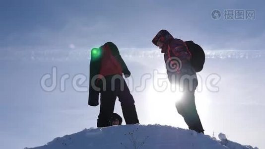 阿拉斯加的旅行者来到雪山的山顶，为战胜冬日的日落而欢欣鼓舞。 人的团队工作视频