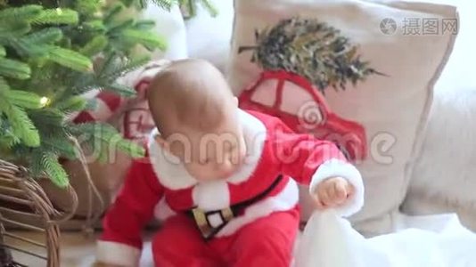 小宝宝坐在地板上，坐在一棵装饰好的圣诞树前的房间里视频
